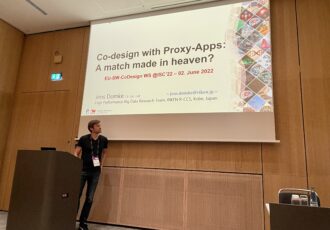 Presenter in front of the wall with the presentation slide "Co-Design with Proxy Apps: A match made in heaven?"